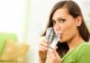 Una donna che beve acqua da un bicchiere
