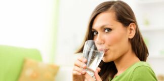 Una donna che beve acqua da un bicchiere