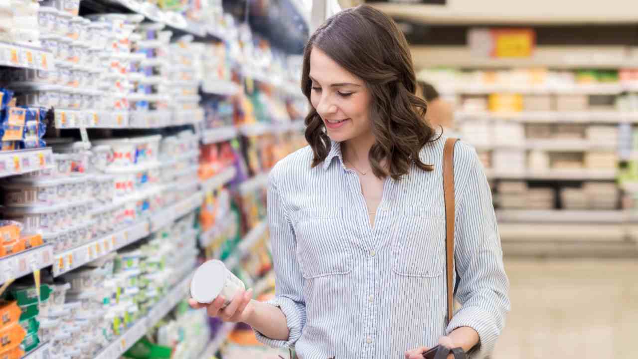 Una donna che compra yogurt al supermercato