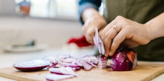 Una persona che affetta una cipolla rossa