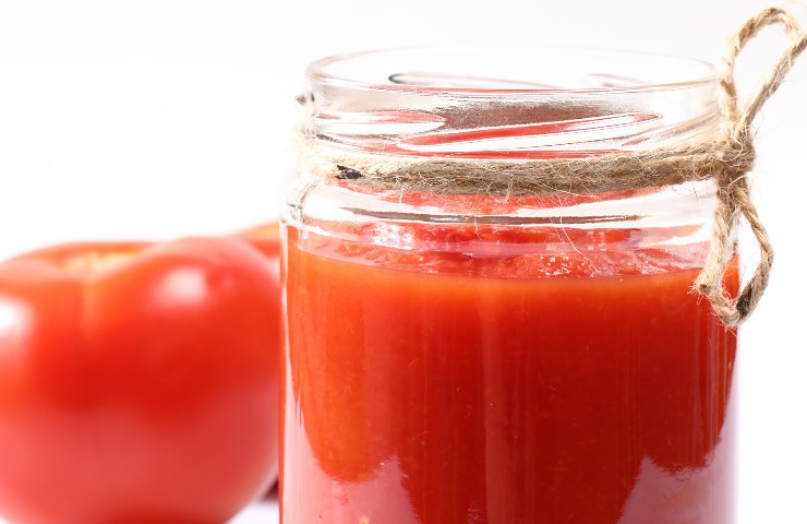 Un barattolo di passata di pomodoro ed un pomodoro