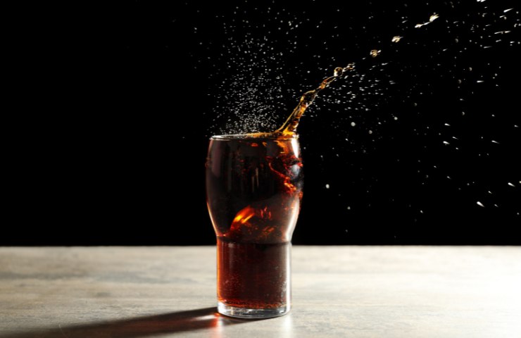 Coca Cola che spruzza dal bicchiere