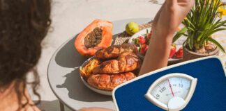 Una persona che mangia in vacanza ed una bilancia