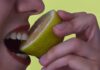Una persona che mangia un limone