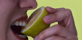 Una persona che mangia un limone