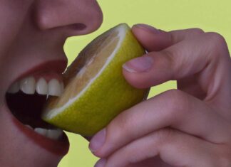 Una persona che mangia un limone