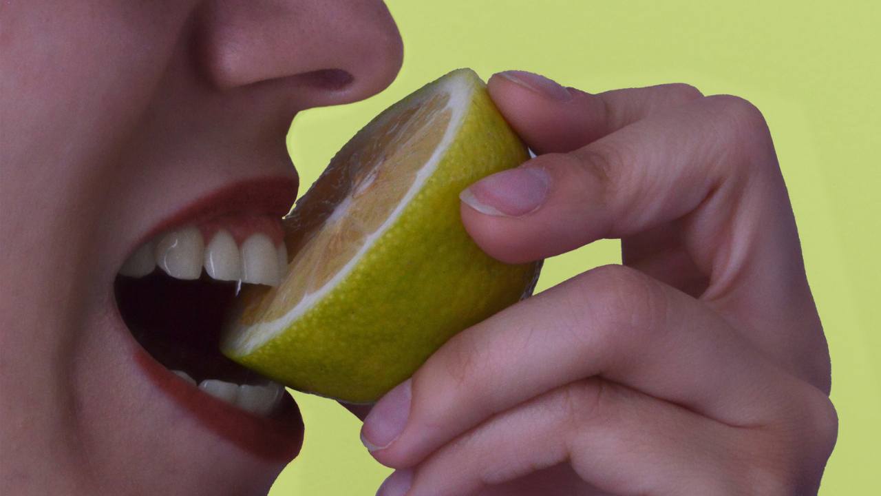 Una persona che mangia un limone