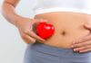 Una donna che poggia un cuore sul ventre
