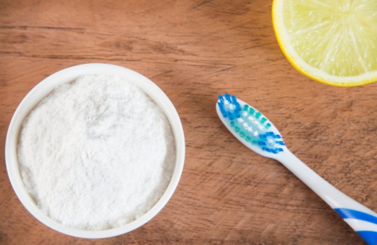 Del bicarbonato di sodio in una ciotola ed un limone ed uno spazzolino
