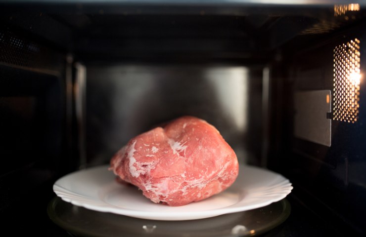 Carne congelata messa in un forno a microonde