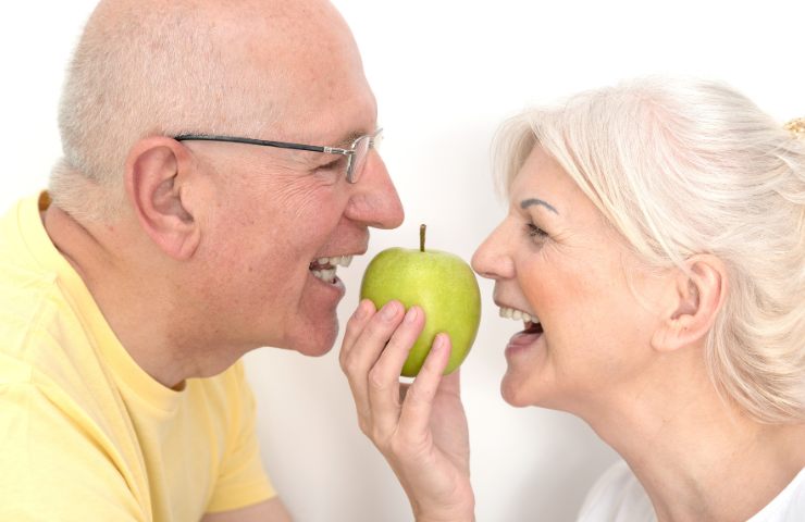 Due anziani felici condividono una mela