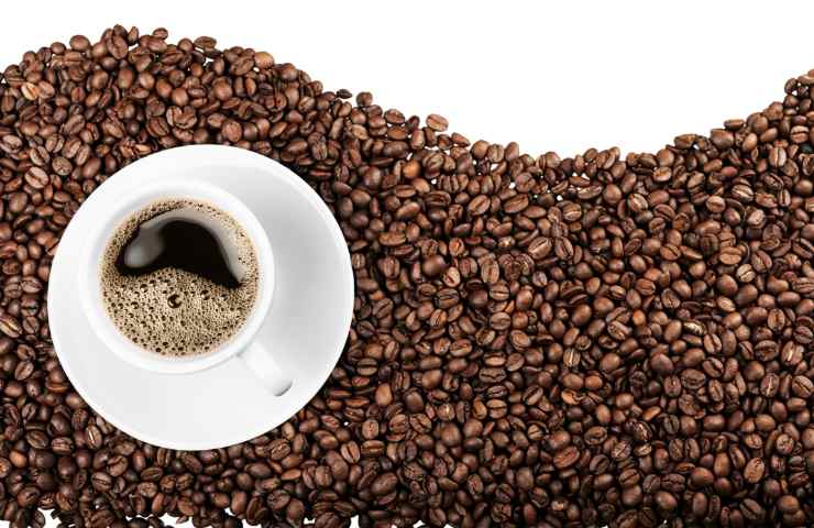 Una tazzina di caffè e dei chicchi