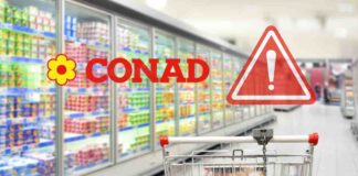 Un carrello con dei banchi frigo ed il logo Conad