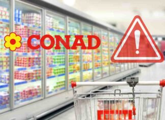 Un carrello con dei banchi frigo ed il logo Conad