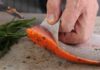 Pulizia di un filetto di salmone dalla sua pelle in corso