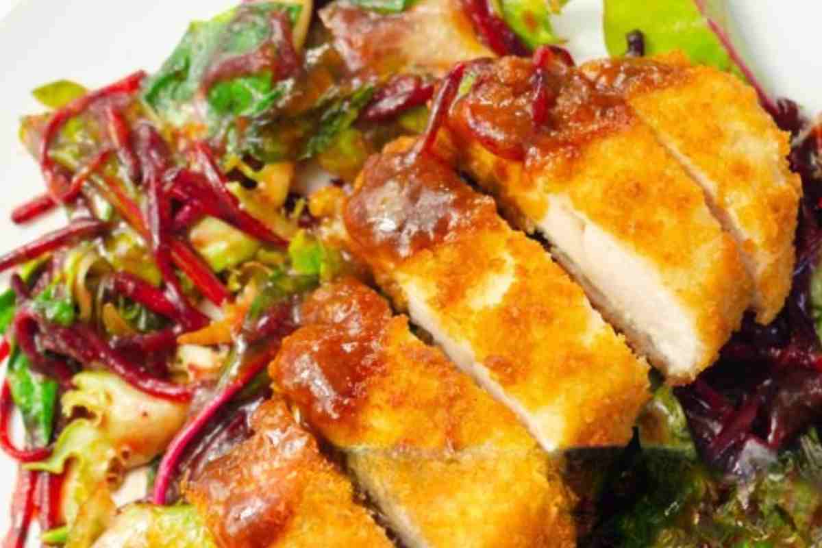 Una cotoletta alla ricotta affettata con verdure