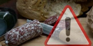 Salame affettato su un piano e segnale di pericolo