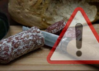 Salame affettato su un piano e segnale di pericolo