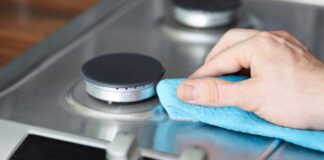 Pulizia dei fornelli della cucina in corso