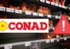 Scaffale di un supermercato e logo Conad con segnale di pericolo