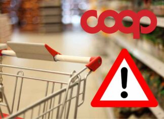 Carrello della spesa in supermercato con logo Coop e segnale di pericolo