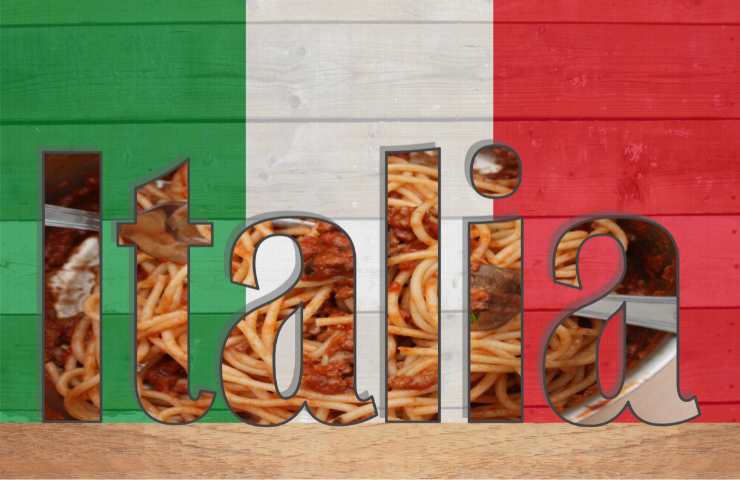 Bandiera italiana e scritta Italia su spaghetti e pomodoro come sfondo