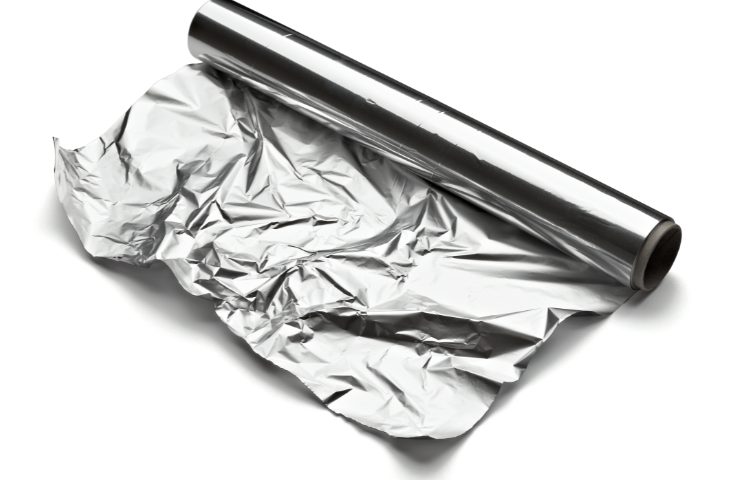 Un rotolo di carta stagnola su sfondo bianco