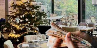 Tavolo in un ristorante a Natale e mani con soldi in euro