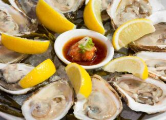 Ostriche crude su un vassoio con fette di limone e salsetta